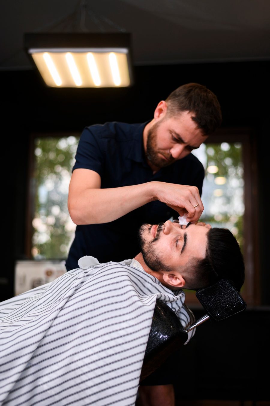 Barber shaving a client at the barbershop